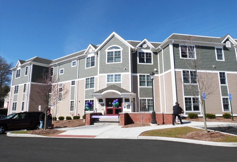 Image of an apartment building with gray paint and white trim